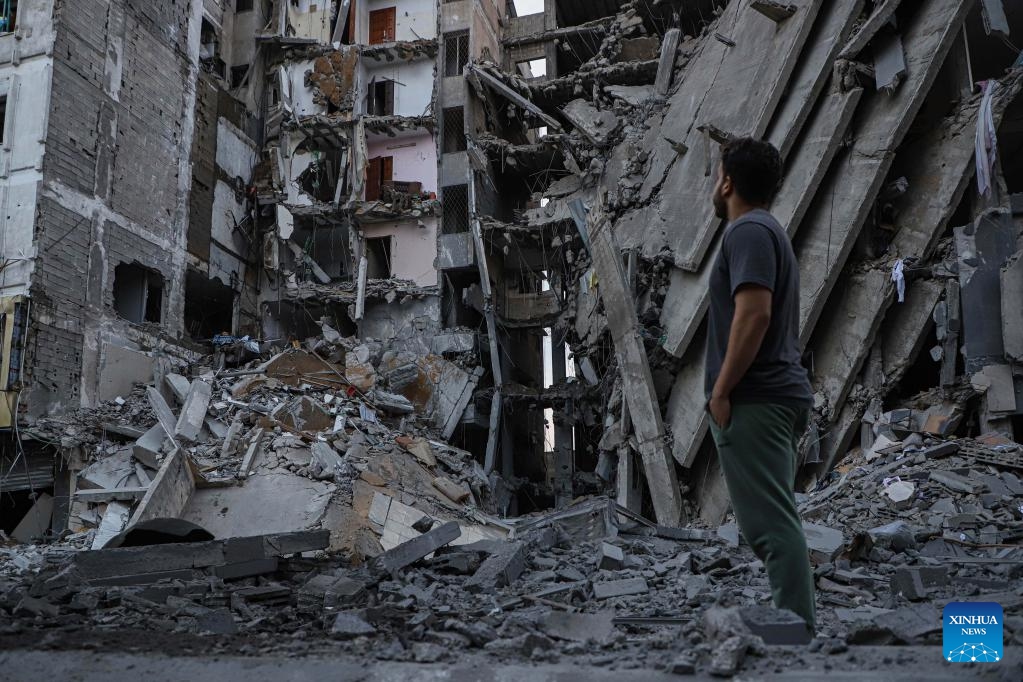 A Palestinian checks destroyed buildings following an Israeli airstrike in Gaza City, Oct. 8, 2023. Israel's cabinet declared a state of war on Sunday after a massive surprise attack launched by Hamas has so far killed at least 700 in Israel while retaliatory Israeli airstrikes killed at least 413 in Gaza.(Photo: Xinhua)