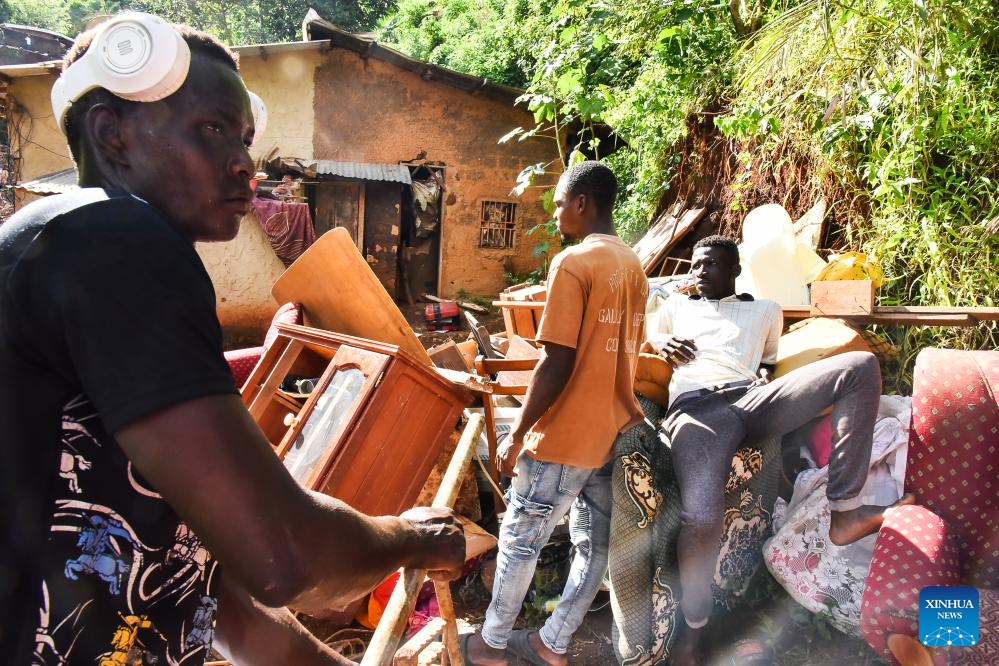 Survivors are seen among their belongings at the site of landslides in Yaounde, Cameroon, on Oct. 9, 2023. Rescuers pulled out three more bodies later Monday after landslides in Yaounde buried homes and buildings Sunday, bringing the death toll of the disaster to 30, officials said.(Photo: Xinhua)