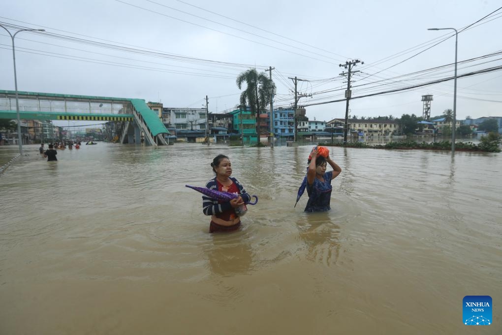 People wade through a flooded area in Bago Region of southern Myanmar, Oct. 10, 2023. Heavy rainfall hit Bago on Sunday.(Photo: Xinhua)