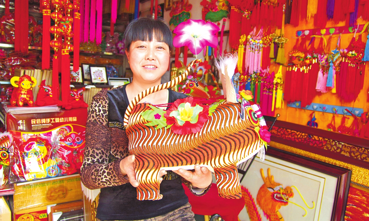An embroiderer shows an embroidered tiger pillow at a workshop in Qianyang, Baoji of Northwest China's Shaanxi Province. Photo: Courtesy of Qianyang Rural Revitalization Administration