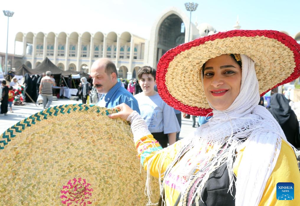 A woman demonstrates a straw hat she made during a traditional cultural event in Tehran, Iran, Oct. 10, 2023.(Photo: Xinhua)