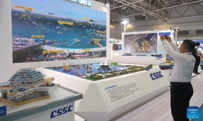 A visitor takes photos of a sand table of marine economy at the China Marine Equipment Expo during the World Marine Equipment Conference 2023 in Fuzhou, southeast China's Fujian Province, Oct. 12, 2023. (Photo: Xinhua)