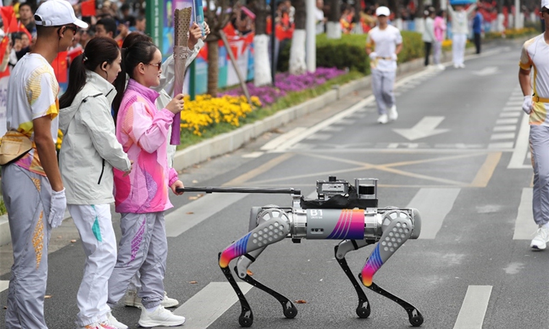 An intelligent guide dog leads a visually impaired torchbearer during the torch relay for the Hangzhou Asian Para Games in the city of Hangzhou in East China's Zhejiang Province on October 19, 2023. Photo: Hangzhou Asian Para Games official website
