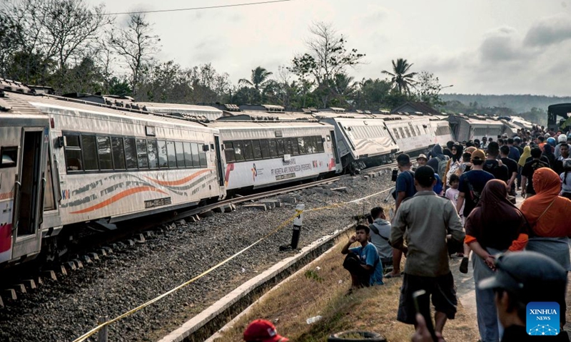 People walk near several carriages of the derailed Argo Semeru train in Kulon Progo Regency, Yogyakarta, Indonesia, Oct. 17, 2023. A total of 32 people were injured in a train accident in Indonesia's Special Region of Yogyakarta on Tuesday, a rescuer said.(Photo: Xinhua)