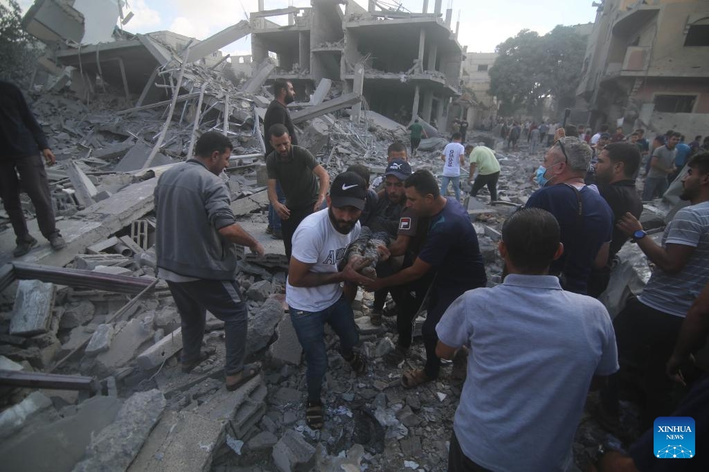 People remove a victim from a building destroyed in Israeli airstrikes in the southern Gaza Strip city of Rafah, on Oct. 17, 2023. The number of Palestinian deaths caused by Israeli airstrikes in Gaza has risen to 3,000, according to the Gaza-based Health Ministry. The Israeli airstrikes were triggered by a large-scale Hamas attack on Israeli military targets and towns on Oct. 7, which has so far killed at least 1,300 people in Israel.(Photo: Xinhua)