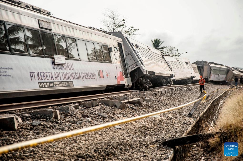 An official stands near several carriages of the derailed Argo Semeru train in Kulon Progo Regency, Yogyakarta, Indonesia, Oct. 17, 2023. A total of 32 people were injured in a train accident in Indonesia's Special Region of Yogyakarta on Tuesday, a rescuer said.(Photo: Xinhua)