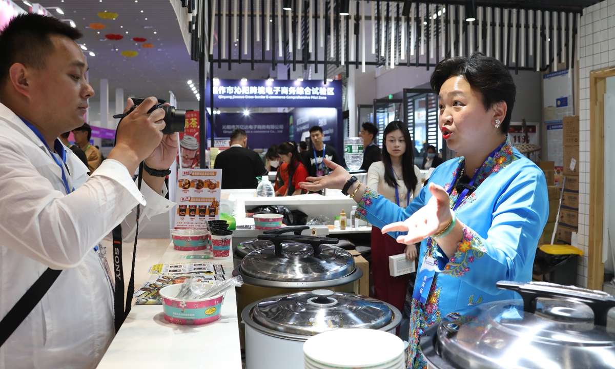 A Malaysian merchant (right) displays her goods during the 7th Global Cross-border E-commerce Conference in Zhengzhou, Central China's Henan?Province, on May 9, 2023. Photo: VCG