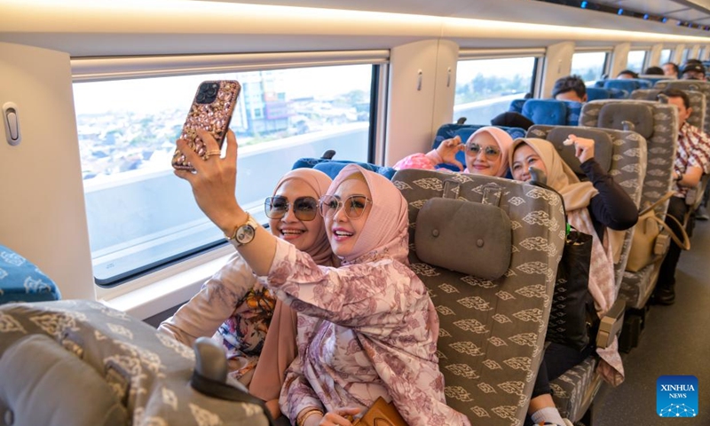 Passengers take selfies in a carriage of a high-speed electrical multiple unit (EMU) train running on the Jakarta-Bandung High-Speed Railway in Indonesia, Oct. 17, 2023. The Jakarta-Bandung High-Speed Railway (HSR) jointly built by China and Indonesia was officially put into commercial operation on Tuesday.(Photo: Xinhua)