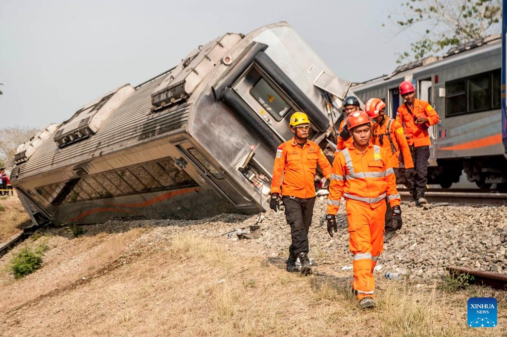 Search and Rescue (SAR) team members walk near several carriages of the derailed Argo Semeru train in Kulon Progo district, Yogyakarta, Indonesia, Oct. 17, 2023. A total of 32 people were injured in a train accident in Indonesia's Special Region of Yogyakarta on Tuesday, a rescuer said.(Photo: Xinhua)