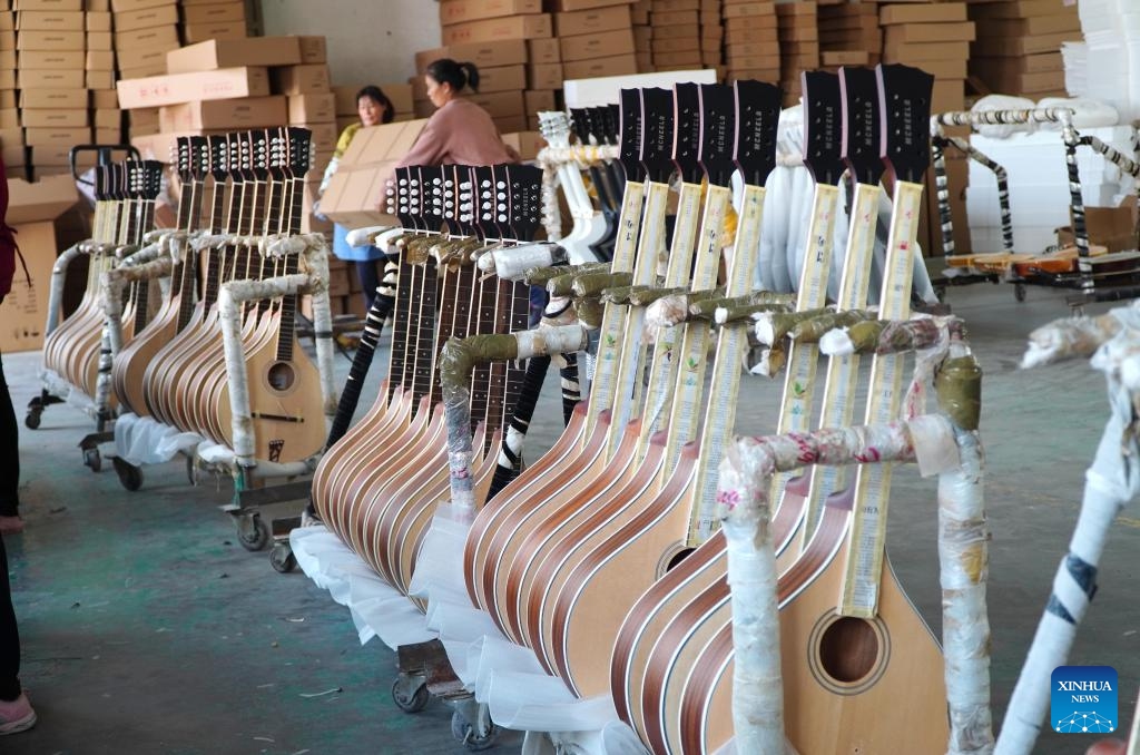 Staff members deliver musical instruments at Tangwu Town of Changle County, east China's Shandong Province, Oct. 17, 2023. Tangwu Town, a town boasting musical instrument production, possesses 108 musical instrument manufacturing and musical instrument accessory processing enterprises, employing over 5000 people. They produce 2 million musical instruments and 5 million instrument accessories annually, generating a main business revenue of 1 billion yuan (about 140 million U.S. dollars).(Photo: Xinhua)