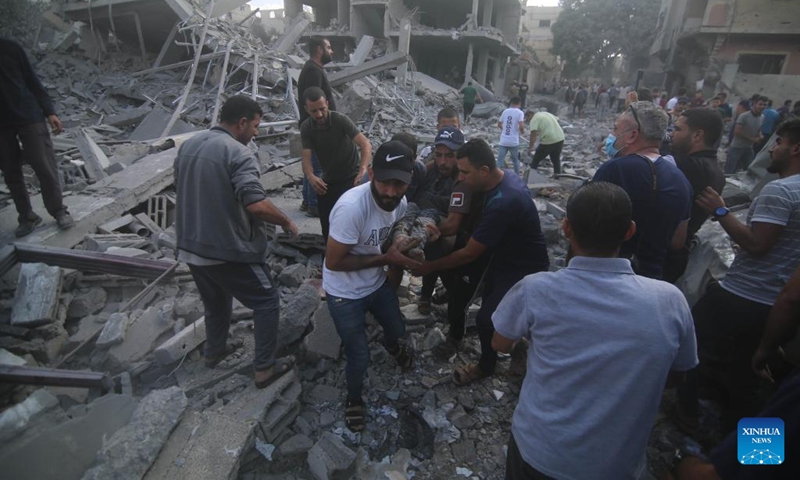 People remove a victim from a building destroyed in Israeli airstrikes in the southern Gaza Strip city of Rafah, on Oct. 17, 2023. Photo: Xinhua