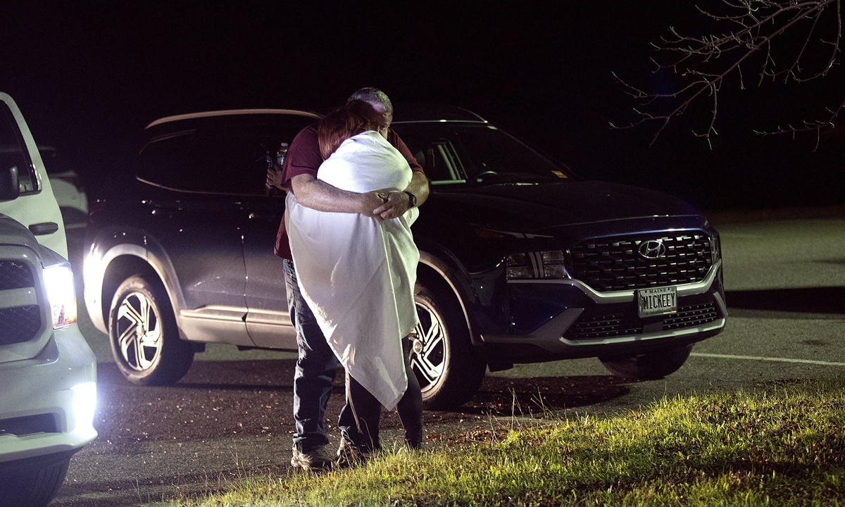 A man and a woman embrace at a reunification center at Auburn Middle School after shootings in Lewiston, Maine, on October 25, 2023. The mass shooting has killed at least 18 people and injured 13 others. An intensive manhunt was underway for the suspect. Photo: VCG