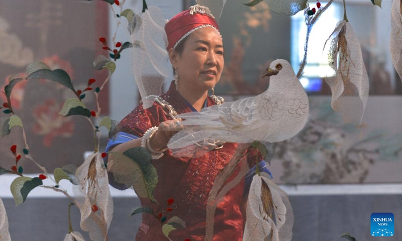 Long Luying checks Miao embroidery decorations at the workshop in Shibing County of Qiandongnan Miao and Dong Autonomous Prefecture, southwest China's Guizhou Province, Oct. 18, 2023. (Photo: Xinhua)