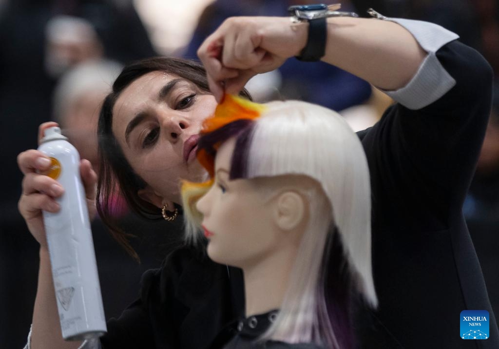Competitors work on models during the Evening Long Hair Elegance competition at the 2023 Beauty X Show in Toronto, Canada, on Oct. 23, 2023.(Photo: Xinhua)