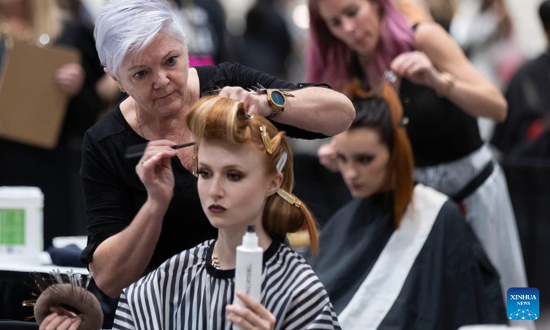 Competitors work on models during the Evening Long Hair Elegance competition at the 2023 Beauty X Show in Toronto, Canada, on Oct. 23, 2023.(Photo: Xinhua)
