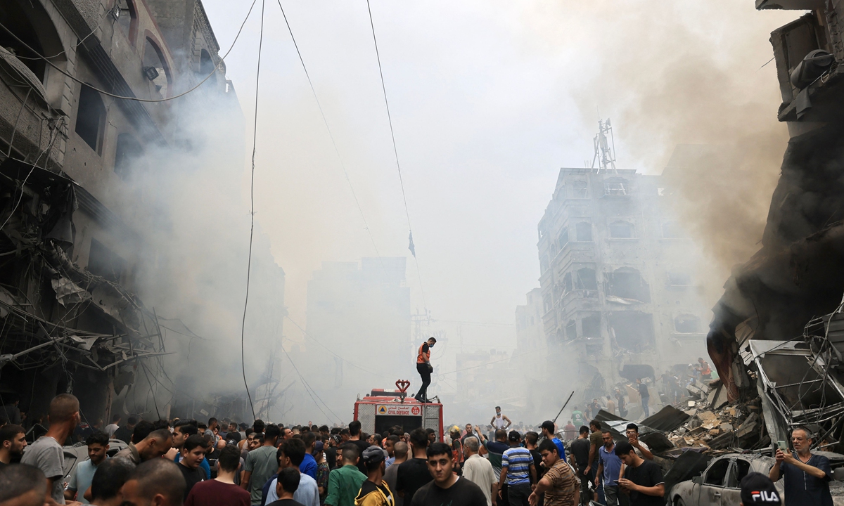Palestinians search for survivors after an Israeli airstrike on buildings in the refugee camp of Jabalia in the Gaza Strip on October 9, 2023. Photo: VCG