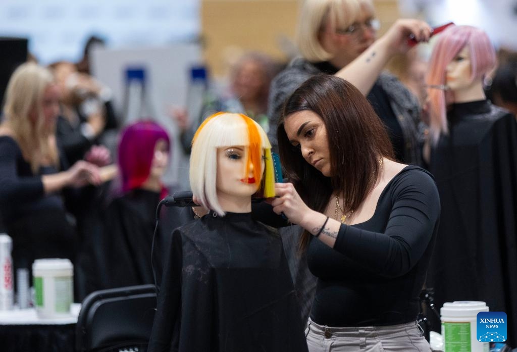 Competitors work on models during the Evening Long Hair Elegance competition at the 2023 Beauty X Show in Toronto, Canada, on Oct. 23, 2023.(Photo: Xinhua)