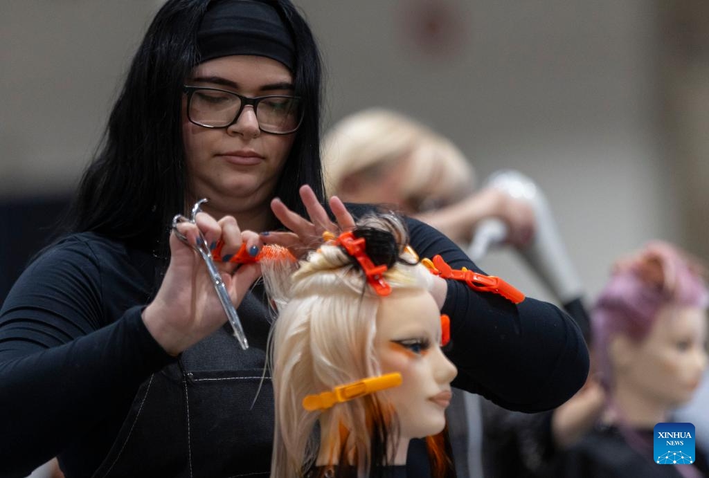 Competitors work on models during the Evening Long Hair Elegance competition at the 2023 Beauty X Show in Toronto, Canada, on Oct. 23, 2023.(Photo: Xinhua)