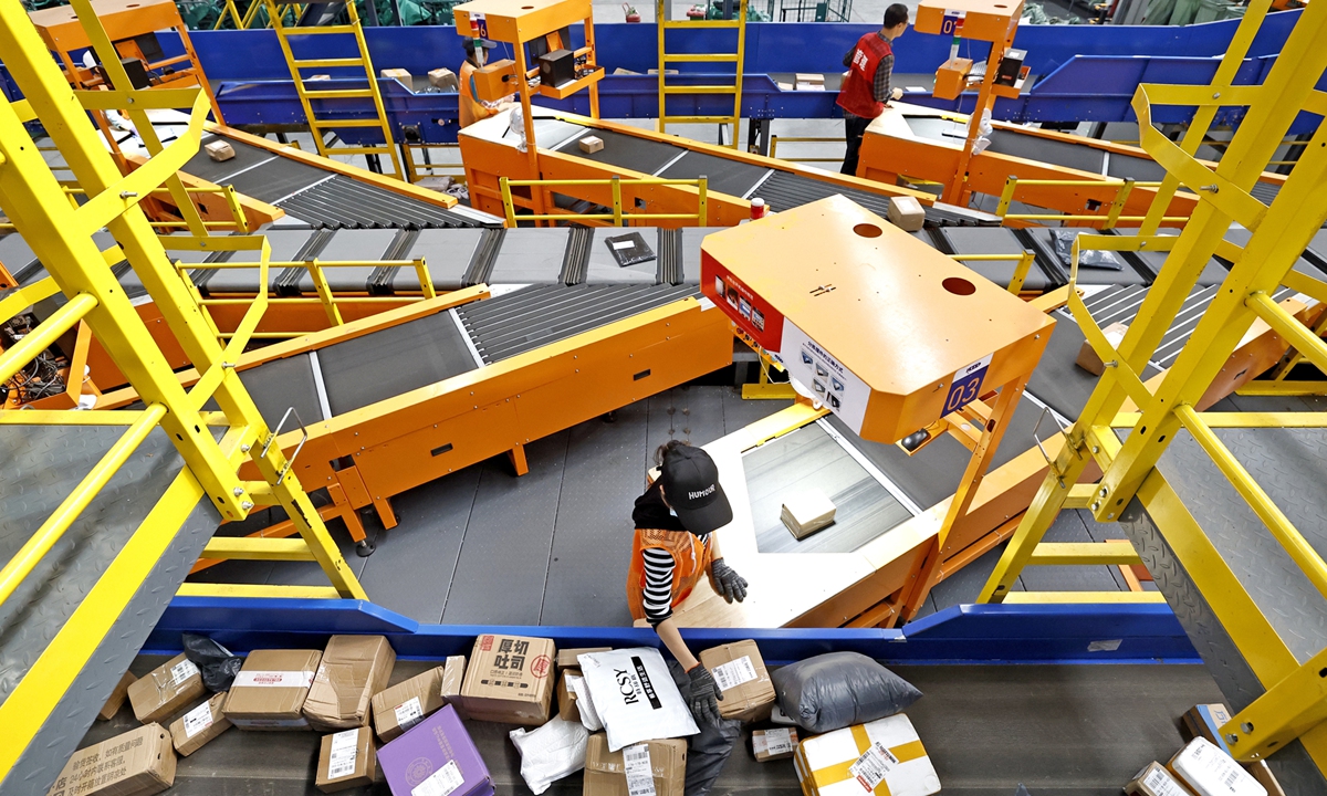 Workers monitor the transfer of parcels through intelligent sorting devices to the corresponding compartments in each village at a logistics center in Xiaogan, Central China's Hubei Province, on October 11, 2023. Photo: IC
