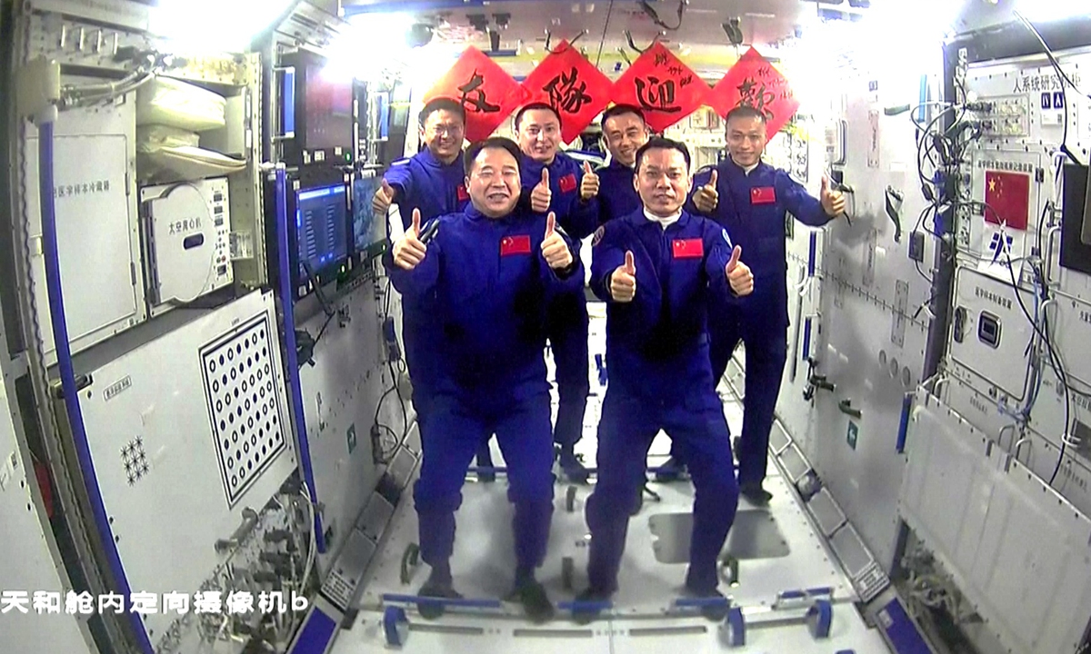Six Chinese taikonauts from two Shenzhou spaceflight mission crews pose at the Chinese space station, after three taikonauts aboard Shenzhou-17 spaceship entered the country's space station on October 26, 2023. The red sheets in the background read Welcome teammates. Photo: CMSA