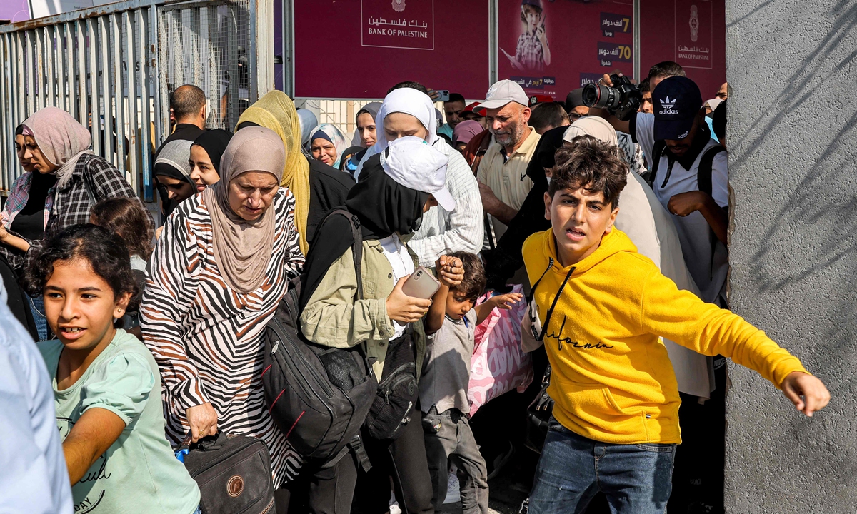 People walk through a gate to enter the Rafah border crossing to Egypt in the southern Gaza Strip on November 1, 2023. Scores of foreign passport holders trapped in Gaza started leaving the war-torn Palestinian territory on November 1 when the Rafah crossing to Egypt was opened up for the first time since October 7. Photo: VCG