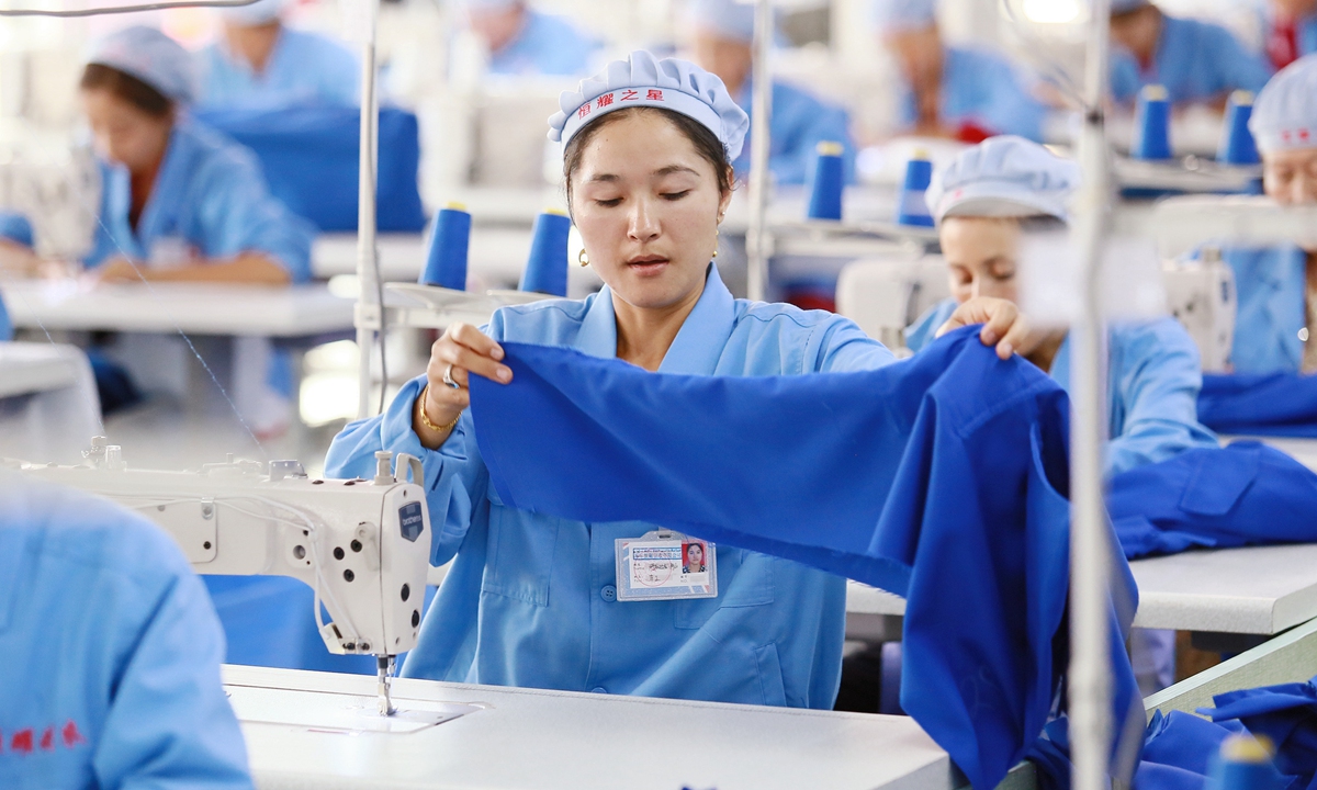 Workers at a garment factory in Aksu Prefecture, Xinjiang, are busy making clothes. Photo: VCG