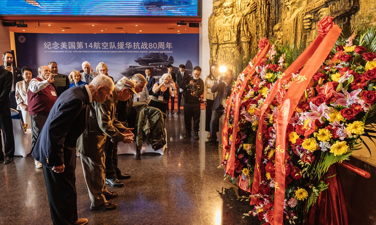 Flying Tigers veterans Harry Moyer (front left) and Melvin McMullen (middle), along with Sino-American Aviation Heritage Foundation president Jeffrey Greene, lay wreathes and bow in front of the statues of the heroes who fought in World War II in Beijing on October 30, 2023. Photo: Li Hao/GT