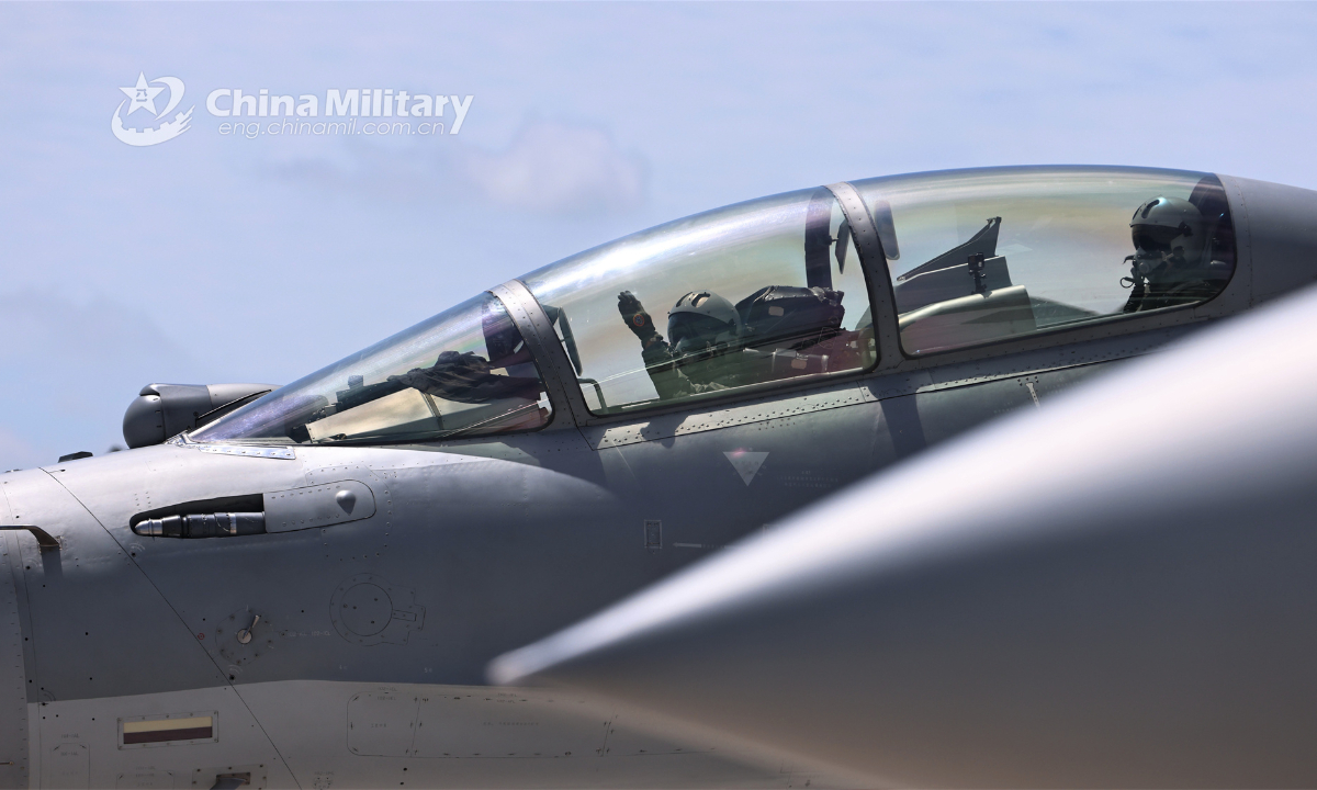 Pilots assigned to an aviation brigade with the air force under the PLA Southern Theater Command give gestures to the ground crew before takeoff during a long-endurance flight training exercise in mid October, 2023. Photo:China Military