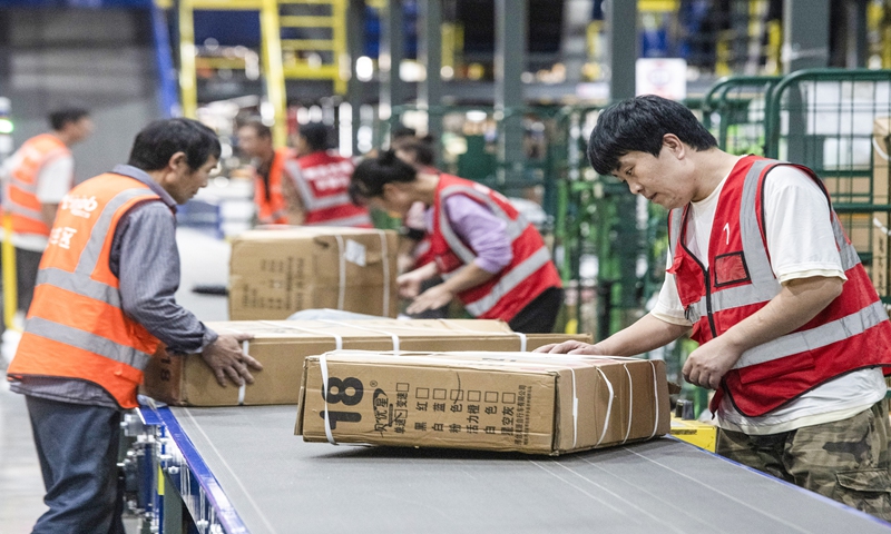 Workers handle express packages in China Post's East China Center located in Jinhua, East China's Zhejiang Province on October 31, 2023, as the annual