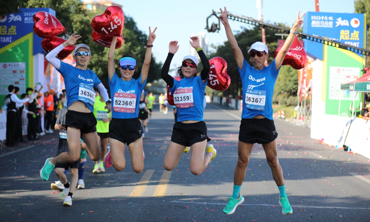 Competitors pose for photos during the 2023 Hengdian Marathon on November 5, 2023, at Hengdian World Studios in Hengdian, East China's Zhejiang Province. Known as the