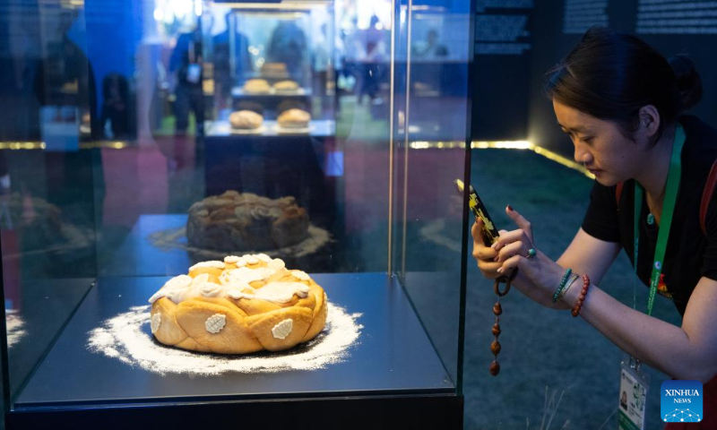 A visitor takes photos of Serbian bread displayed at the booth of Serbia at the 6th China International Import Expo (CIIE) in East China's Shanghai, November 6, 2023. Photo: Xinhua