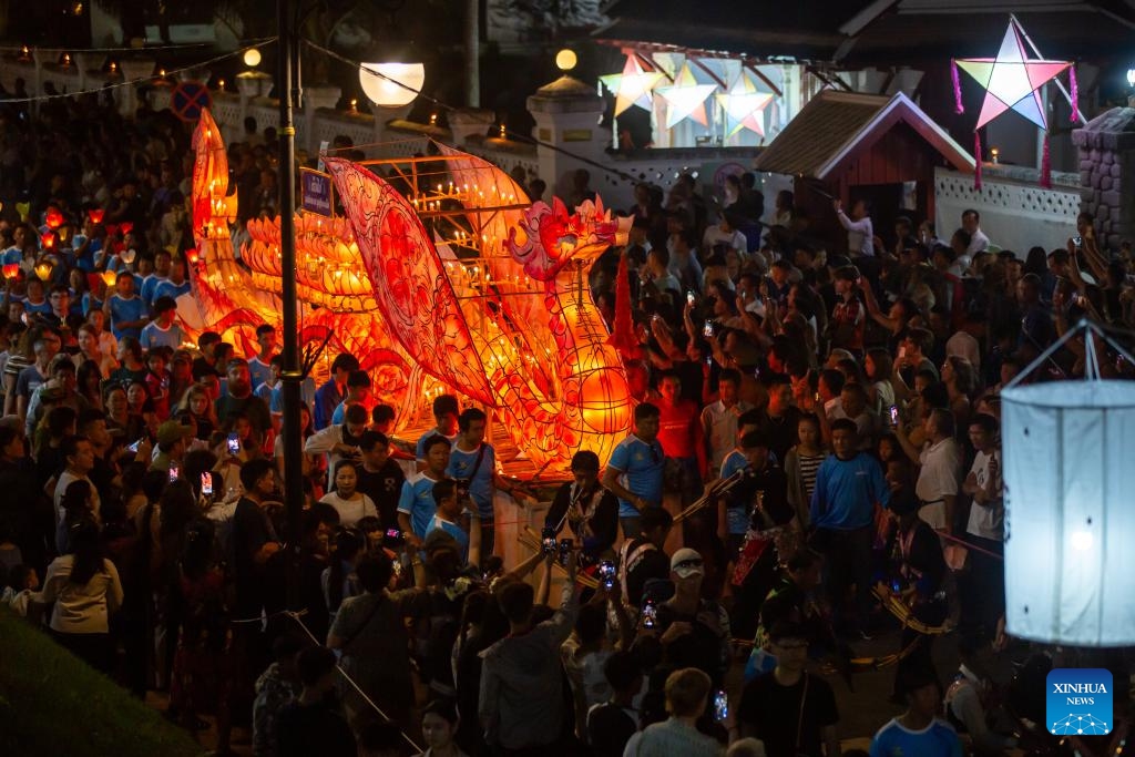 People take part in a parade with a light boat in Luang Prabang, Laos, on Oct. 30, 2023. Boun Lai Heua Fai, a light boat festival, was held in the northern Lao world heritage town of Luang Prabang on Monday.(Photo: Xinhua)
