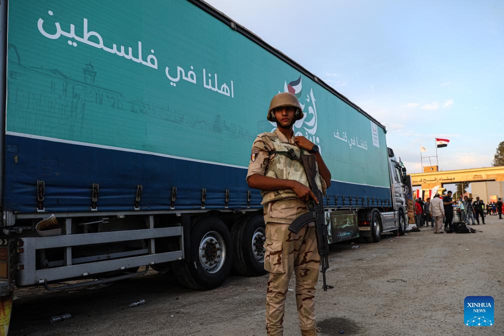 A soldier stands guard in front of a truck carrying relief aid near the Egyptian side of the Rafah crossing, on Oct. 31, 2023. Hundreds of trucks carrying relief aid have waited for days at the Egyptian side of the Rafah crossing to enter the war-torn Gaza Strip, home to 2.3 million Palestinians who have been deprived of fuel, food, water and medical supplies for nearly three weeks under Israeli blockades.(Photo: Xinhua)