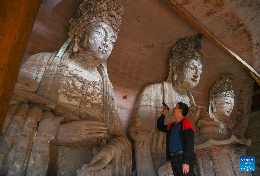 A volunteer conducts an inspection tour at a cultural relics protection site of Dazu Rock Carvings in Baoding Town of Dazu District, southwest China's Chongqing Municipality, Oct. 31, 2023. Dazu Rock Carvings originated from Sichuan and Chongqing regions in ancient China. In 1999, the carvings were added to the UNESCO World Heritage List as a cultural heritage site.(Photo: Xinhua)