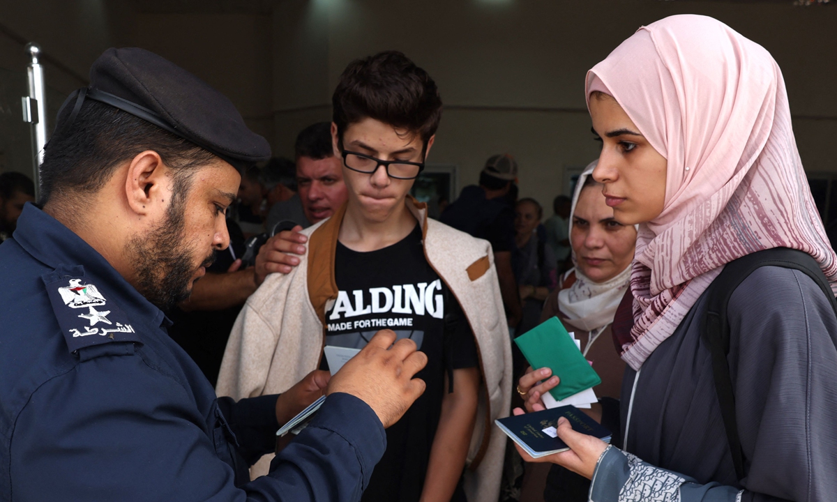 Dual nationality Palestinians show their documents as they cross the Rafah border point with Egypt in the southern Gaza Strip on November 2, 2023. Egypt will help evacuate about 7,000 foreigners and dual nationals from the war-ravaged Gaza Strip, the foreign ministry said. Photo: VCG