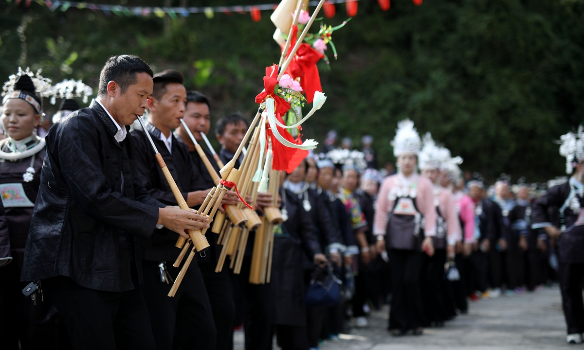Villagers of the Miao ethnic group play traditional musical instruments during the 