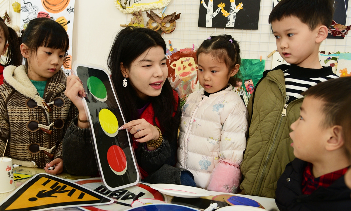 A college student volunteer explains traffic knowledge to children at a kindergarten in Zhenjiang, East China's Jiangsu Province, on November 27, 2023. December 2 marks the 12th National Traffic Safety Day this year. Photo: VCG