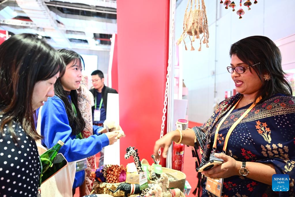 Tahera Toma, Nurus Safa's wife, introduces products at their booth during the 6th China International Import Expo (CIIE) in east China's Shanghai, Nov. 7, 2023. In 2018, Nurus Safa, founder of Dada Bangla Limited, participated in the expo for the first time, and his special products such as jute carpets, baskets and bags went popular at the time. During the past years, Safa's business has grown bigger and brought thousands of job opportunities to Bangladeshi families.(Photo: Xinhua)