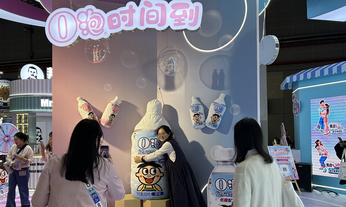 Visitors take pictures at the booth of Want-Want Group at the CIIE in Shanghai on November 9, 2023.  Photo: Qi Xijia/GT