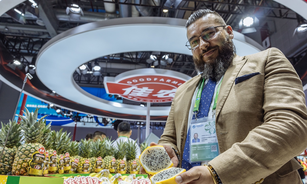 Jorge Cevallos, commercial counselor of the Ecuadorian Embassy to China, shows the yellow dragon fruit at the 6th CIIE held in Shanghai. Photo: Li Hao/GT
