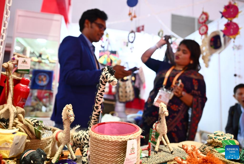Nurus Safa talks with his wife Tahera Toma at their booth during the 6th China International Import Expo (CIIE) in east China's Shanghai, Nov. 7, 2023. In 2018, Nurus Safa, founder of Dada Bangla Limited, participated in the expo for the first time, and his special products such as jute carpets, baskets and bags went popular at the time.(Photo: Xinhua)