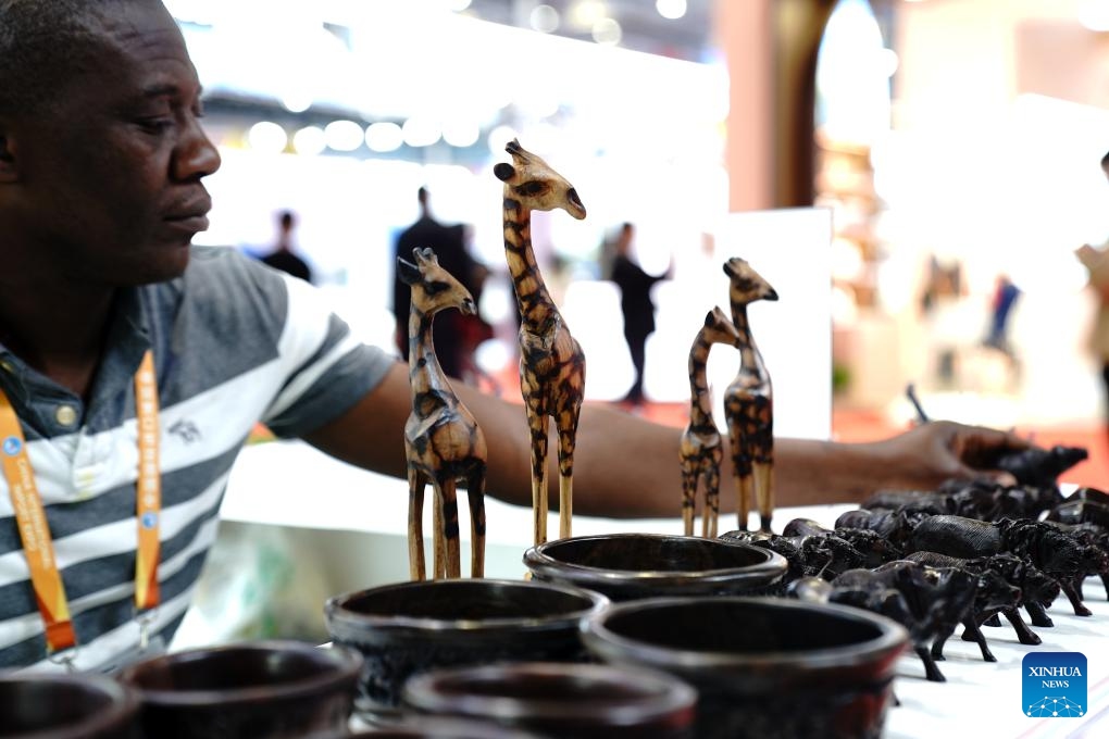 A Zimbabwean exhibitor arranges exhibits at the 6th China International Import Expo (CIIE) in east China's Shanghai, Nov. 8, 2023. Besides business opportunities, the ongoing expo in Shanghai also provides a stage for exhibitors from different countries and regions to showcase their unique culture to the world.(Photo: Xinhua)