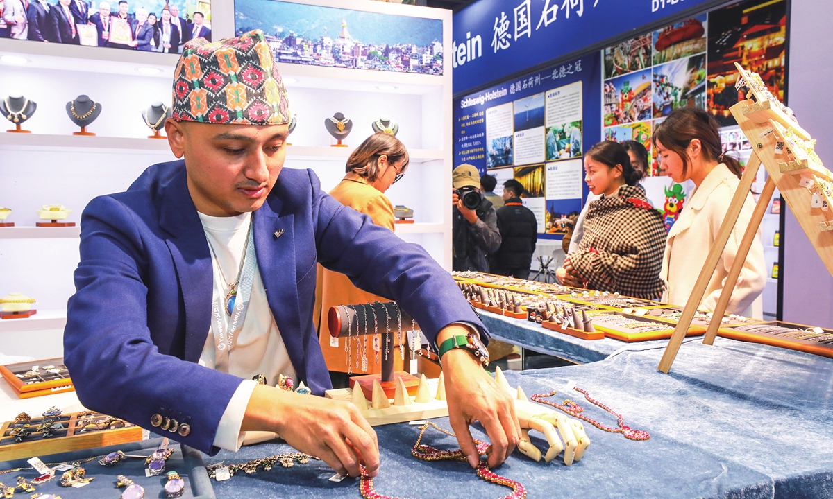 A Nepalese trader displays local jewelry at an imported commodities fair in Yiwu, East China's Zhejiang Province on November 13, 2023. The fair has attracted more than 1,000 exhibitors from 81 countries and regions around the world, mainly showcasing imported food, apparel and accessories and home furnishings. Photo: VCG