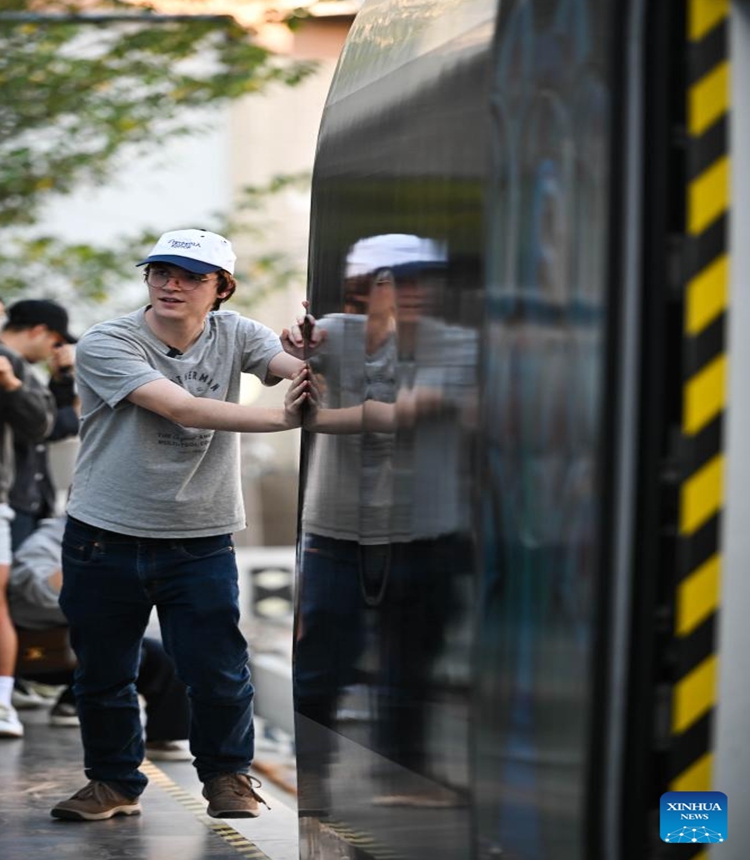 A U.S. student participating in the China Education Tour learns about a prototype locomotive using high-temperature superconducting (HTS) maglev technology in Chengdu, southwest China's Sichuan Province, Nov. 6, 2023. More than 20 young people from the United States participated in the China Education Tour in southwest China's Sichuan Province recently. (Photo: Xinhua)