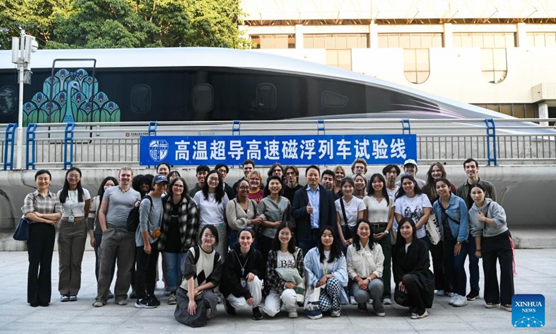U.S. students participating in the China Education Tour pose for a group photo besides a prototype locomotive using high-temperature superconducting (HTS) maglev technology in Chengdu, southwest China's Sichuan Province, Nov. 6, 2023. More than 20 young people from the United States participated in the China Education Tour in southwest China's Sichuan Province recently. (Photo: Xinhua)