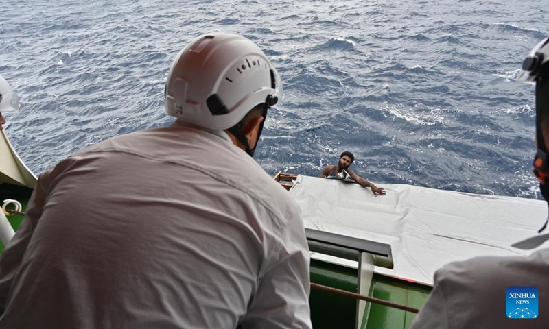 A member of China's 40th Antarctic expedition team communicates with a crew member of the rescued fishing boat aboard China's research icebreaker Xuelong 2 on Nov. 10, 2023.(Photo: Xinhua)