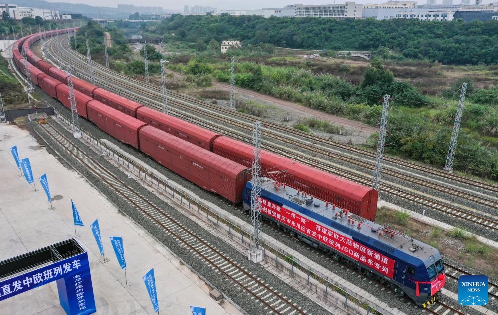 This aerial photo taken on Nov. 14, 2023 shows a JSQ freight train departing at Langantan Station in Yongchuan District of southwest China's Chongqing. The first JSQ freight train from Yongchuan District of southwest China's Chongqing directly to Europe departed on Tuesday. The train is loaded with 232 vehicles manufactured by Great Wall Motors in Yongchuan, with a total value of about 42 million yuan (about 5.76 million U.S. dollars).(Photo: Xinhua)