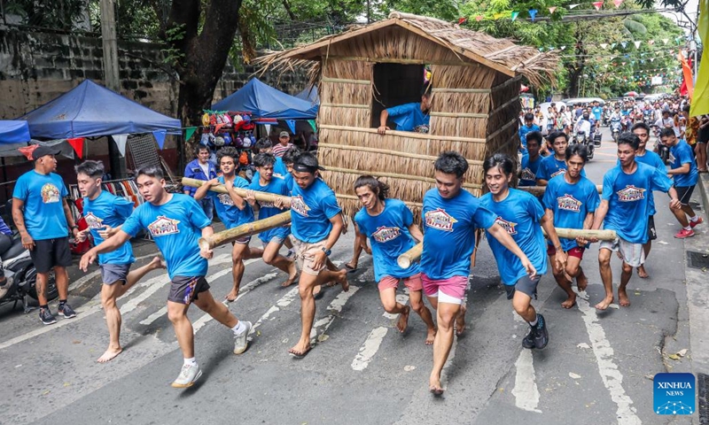 Residents participate in the Buhat Kubo (nipa hut carrying) race in Pasig City, the Philippines, Nov. 18, 2023. The Buhat Kubo race was held as part of the annual Bayanihan Festival. (Photo: Xinhua)