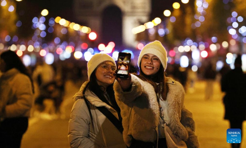 People take selfies at Champs-Elysees Avenue lit by Christmas season lights in Paris, France, Nov. 19, 2023. The annual Christmas season lighting ceremony was held here on Sunday(Photo: Xinhua)