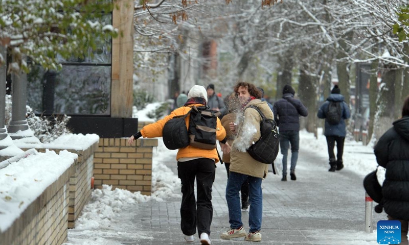 People walk on the street after the first snowfall of this winter in Kiev, Ukraine, Nov. 22, 2023.(Photo: Xinhua)